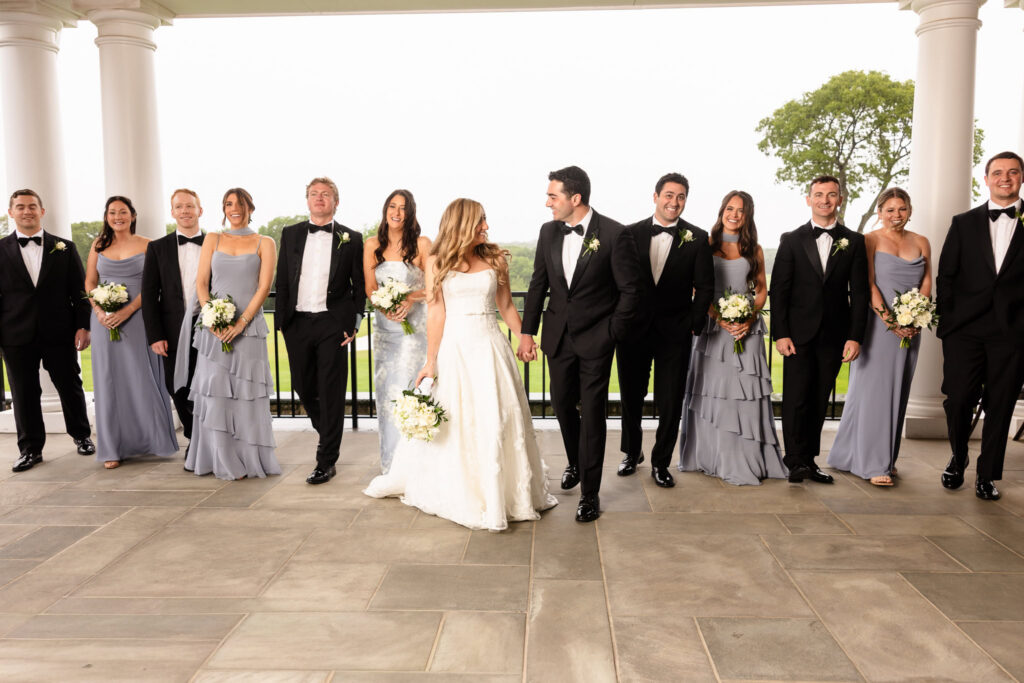 Bridal party walking with the bride and groom during a Huntington Crescent Club wedding on the outdoor terrace.
