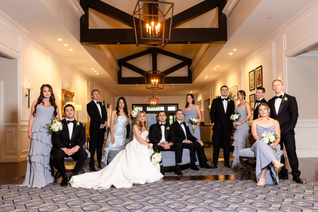 Elegant bridal party portrait inside Huntington Crescent Club featuring the bride, groom, bridesmaids, and groomsmen.