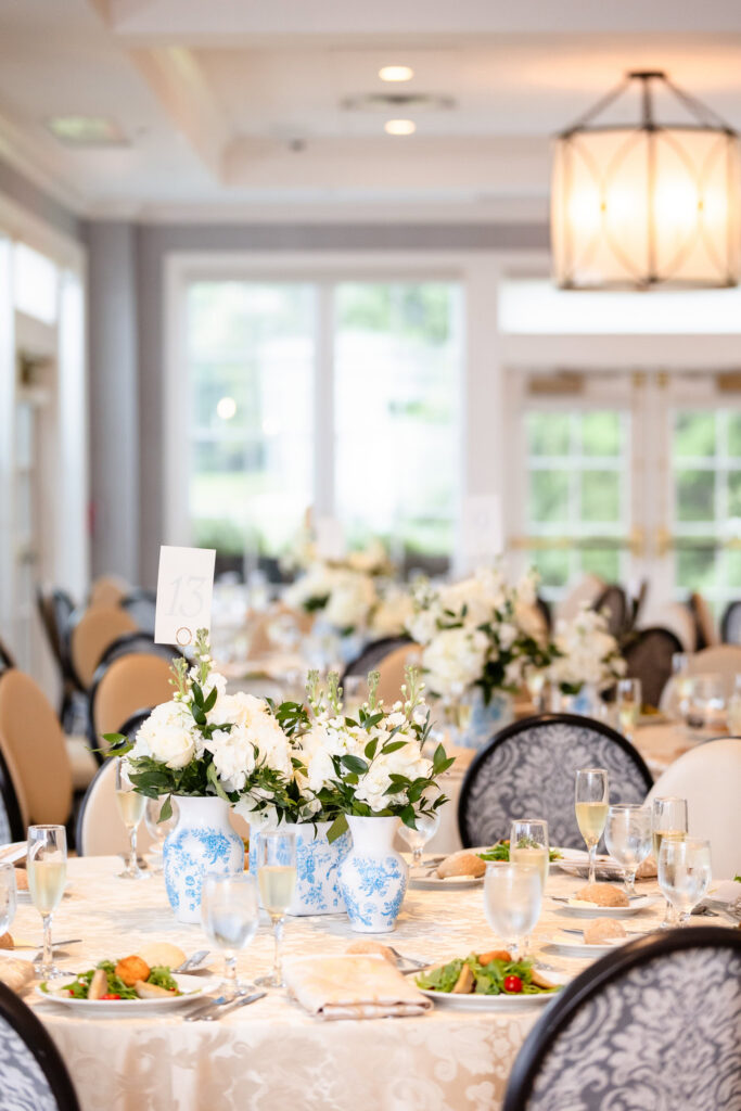 Elegant reception décor with blue and white floral arrangements prepared for guests at a Huntington Crescent Club wedding.