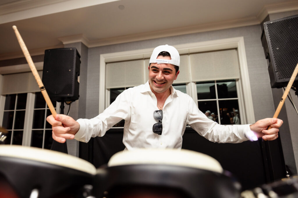 Groom playing the drums during the wedding reception entertainment.