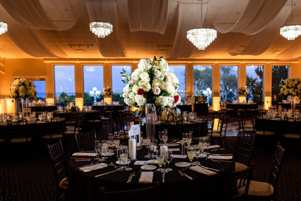 Elegant reception ballroom setup with tall floral centerpieces at Land's End.