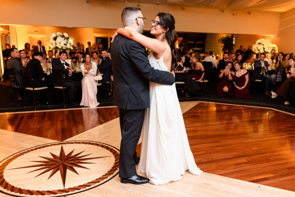 Newlyweds dancing together surrounded by guests at Land's End.