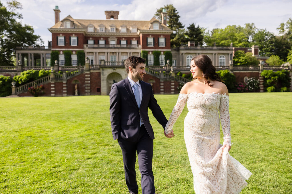 Couple walking across the lawn with Westbury House in the background.