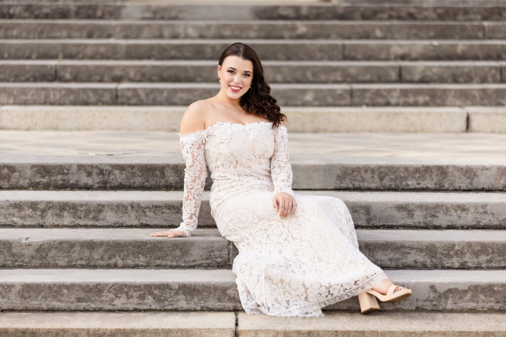 Bride seated on the grand stone staircase during an editorial Old Westbury Gardens engagement session.
