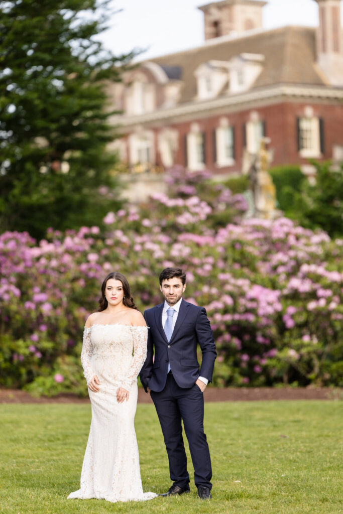 Editorial-style portrait of an engaged couple standing in the formal gardens during an Old Westbury Gardens engagement session.