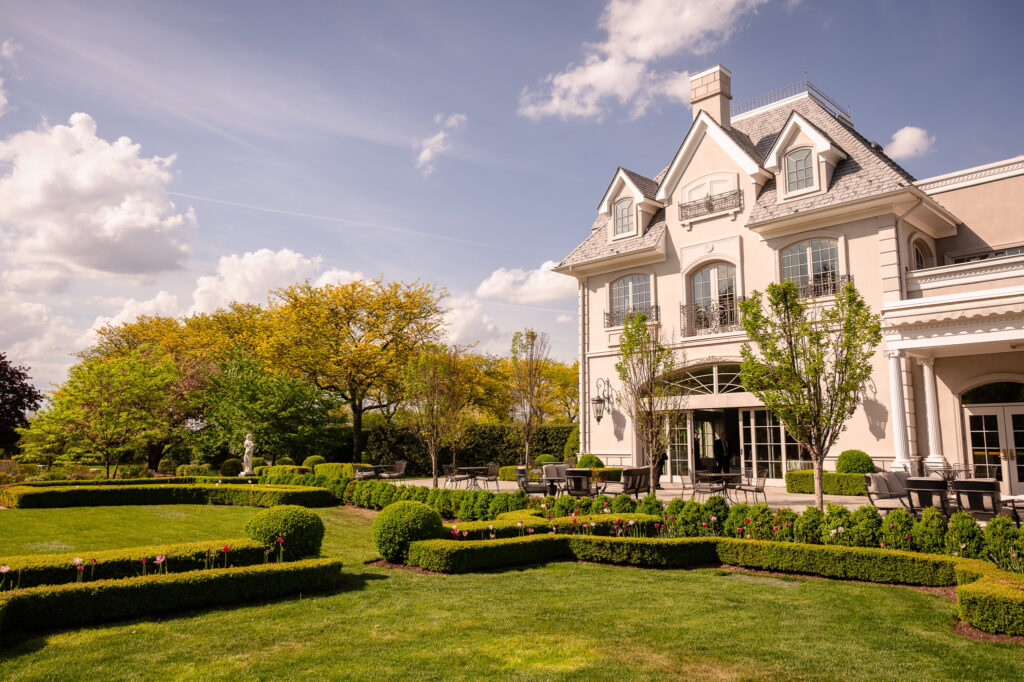 Exterior view of Park Chateau Estate and Gardens featuring formal landscaping and European-inspired architecture.
