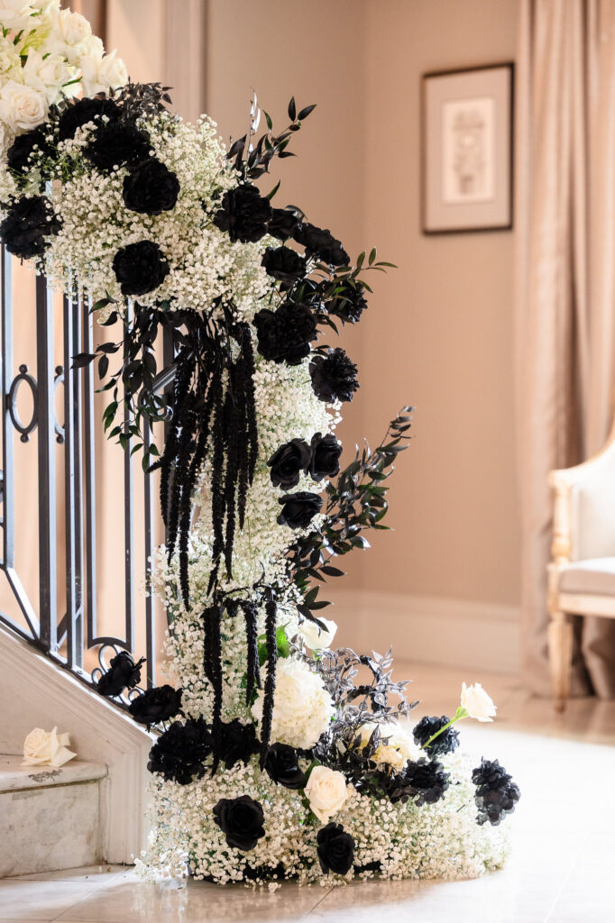 Grand staircase floral installation at a Park Chateau Wedding featuring dramatic black and white floral design.