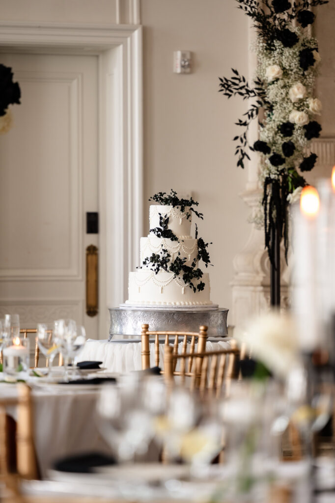 Elegant wedding cake display at a Park Chateau Wedding reception surrounded by refined floral decor.