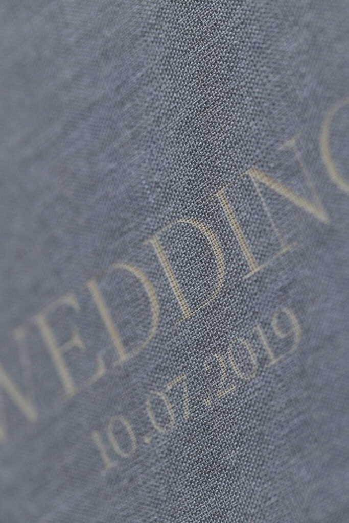 Close-up of a personalized linen wedding album cover with foil stamping.
