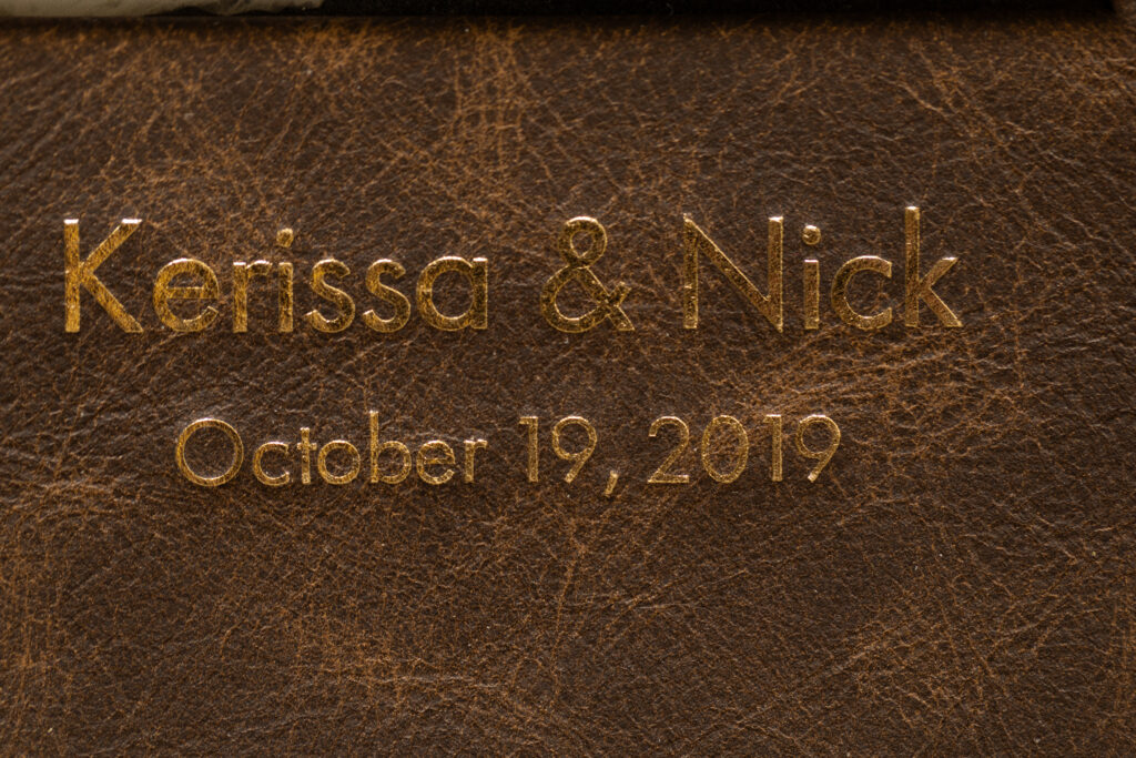 Close-up of personalized leather wedding album with gold foil embossing.