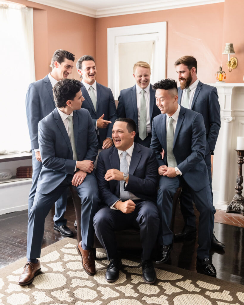 Robbie laughs with his groomsmen during a candid portrait before the wedding ceremony.