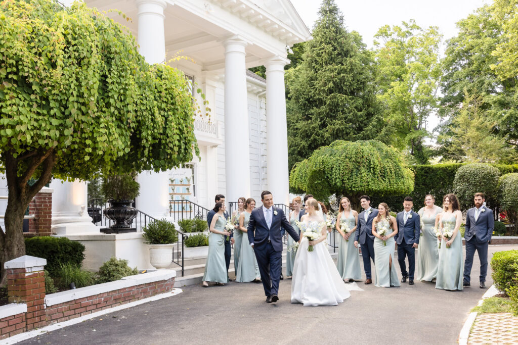 Lydia and Robbie walk with their bridal party in front of The Briarcliff Manor during their June wedding in Westchester County.