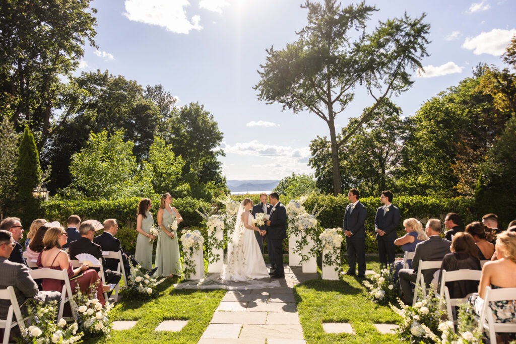 Lydia and Robbie exchange vows during their outdoor ceremony overlooking the Hudson River at The Briarcliff Manor.