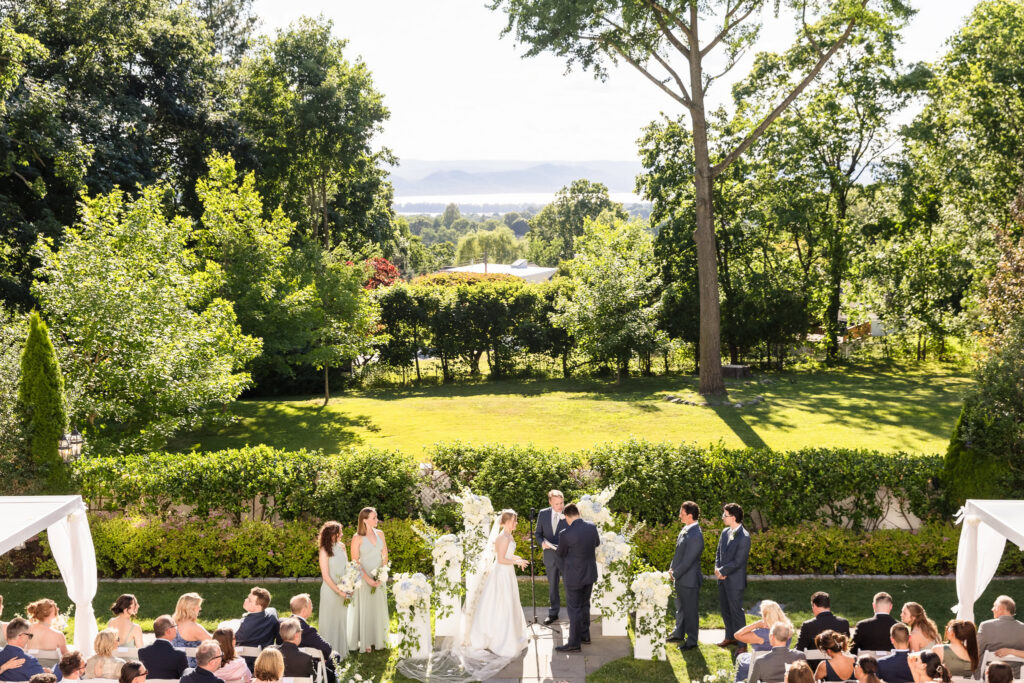An elevated view of Lydia and Robbie's outdoor wedding ceremony with the Hudson River in the distance at The Briarcliff Manor.