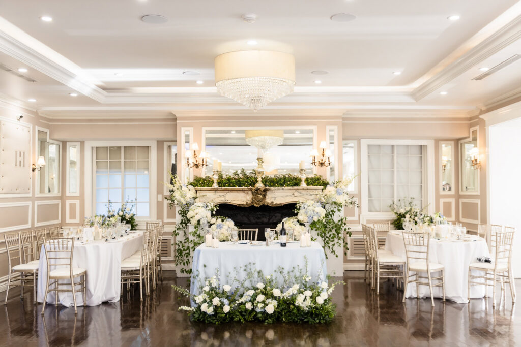 The elegant reception space at The Briarcliff Manor featuring the sweetheart table, fireplace, and floral arrangements.