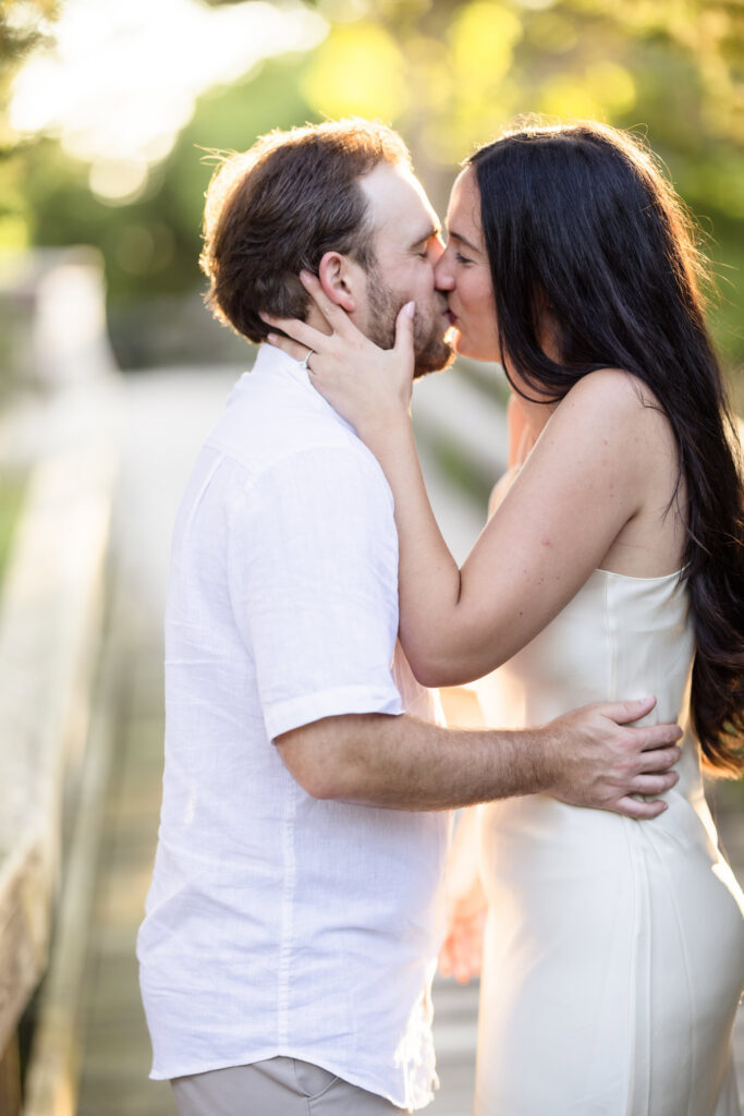 Catie and Zach share a kiss in warm golden hour light during their Fire Island National Seashore engagement session.