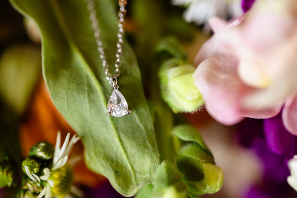Pear-shaped bridal necklace photographed among the bouquet details before a Harbor Club at Prime wedding.