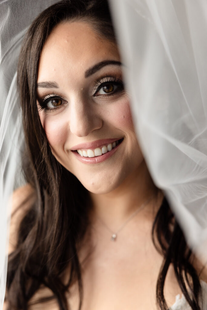 Bridal portrait framed by the veil before a Harbor Club at Prime wedding overlooking Huntington Harbor.