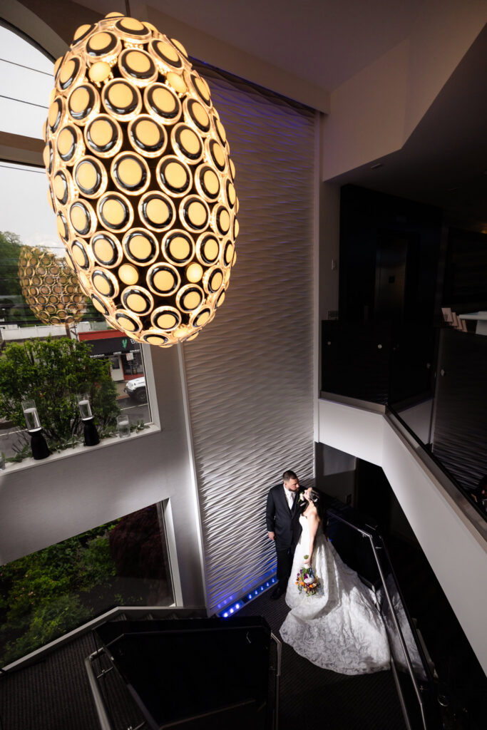 Bride and groom posing on the dramatic staircase before their Harbor Club at Prime wedding portraits.