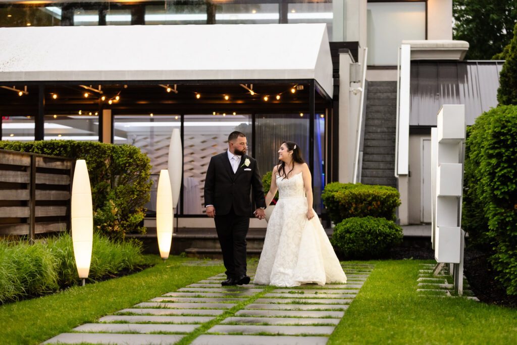 Bride and groom walking hand in hand outside during their Harbor Club at Prime wedding at the waterfront venue.