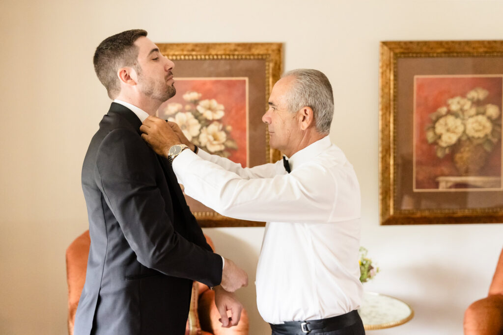 Joe's father adjusts his bow tie and tuxedo before leaving for St. Brigid's Roman Catholic Church.