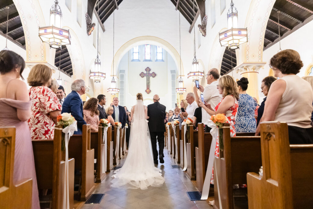 Lauren walks down the aisle with her father at St. Brigid's Roman Catholic Church in Westbury surrounded by family and friends.