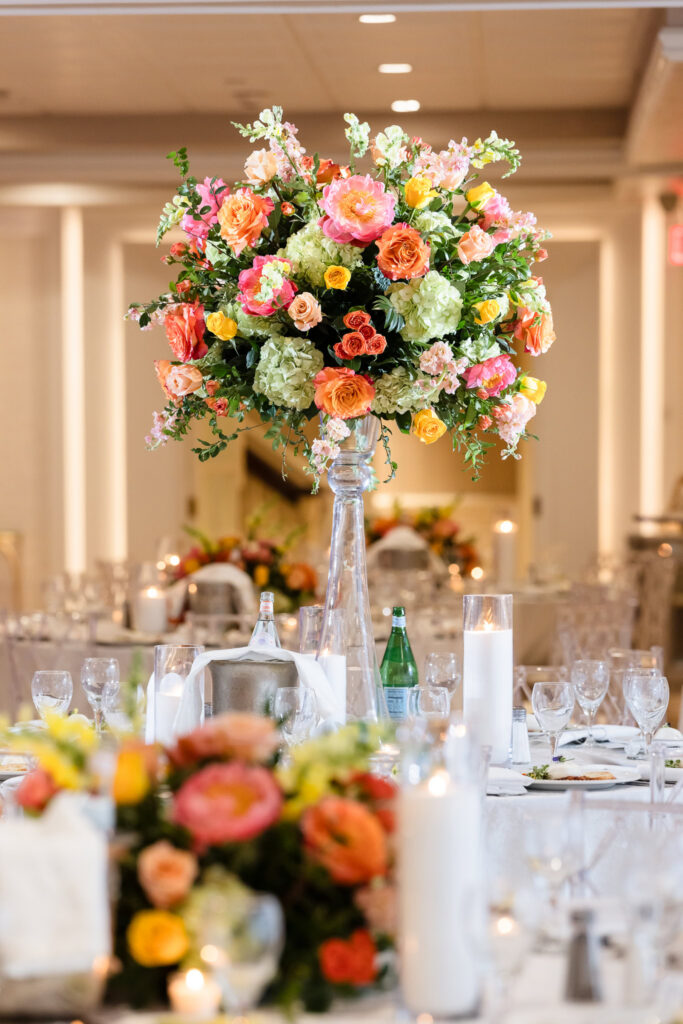 Close-up of a colorful floral centerpiece featuring roses, peonies, and hydrangeas decorating the reception tables at Watermill Caterers.