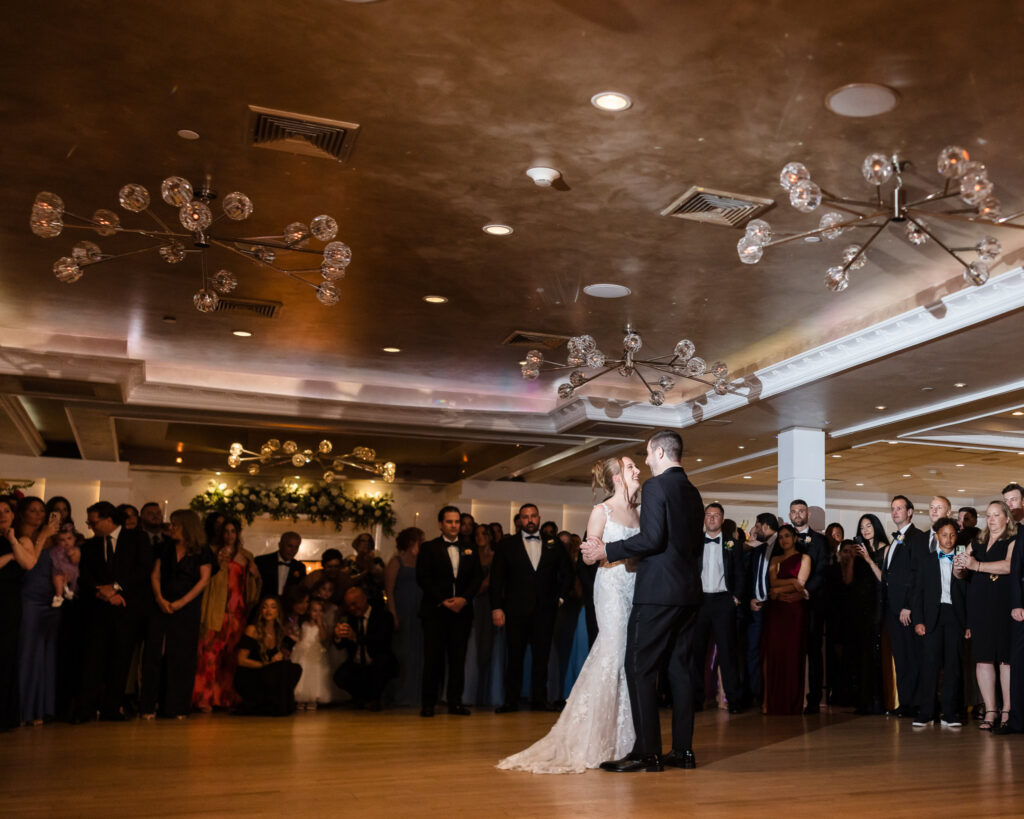 Lauren and Joe sharing their first dance surrounded by family and friends during their reception at Watermill Caterers.