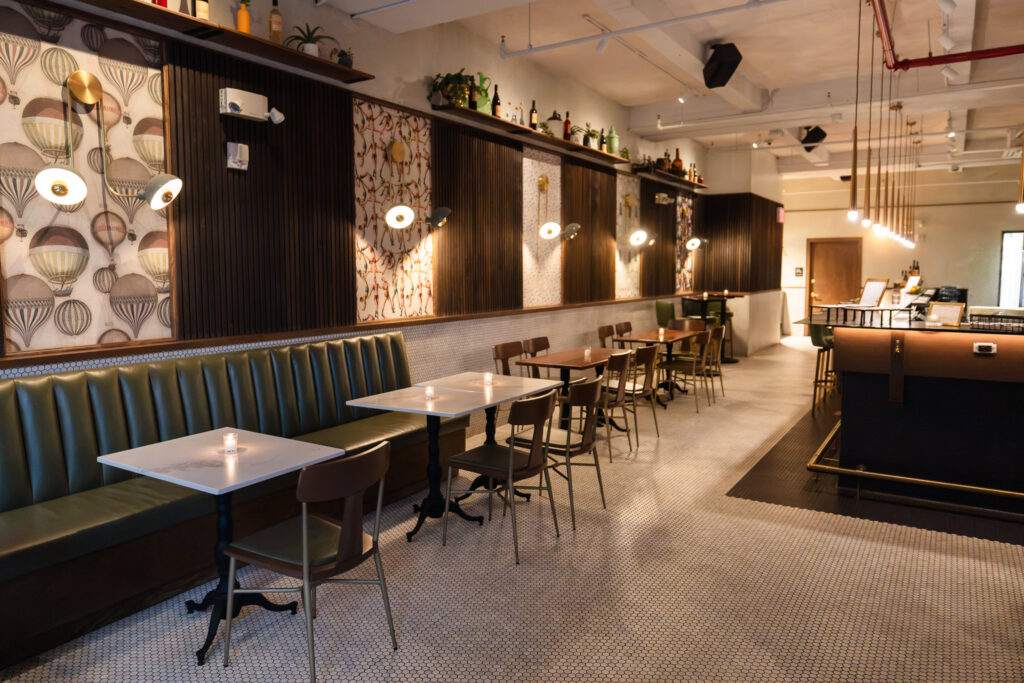Interior of Brooklyn Winery in Williamsburg with banquette seating, patterned walls, and warm modern lighting.