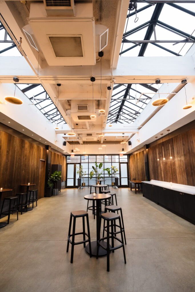 Vertical view of the Brooklyn Winery wedding space highlighting its expansive skylights and modern pendant lighting.