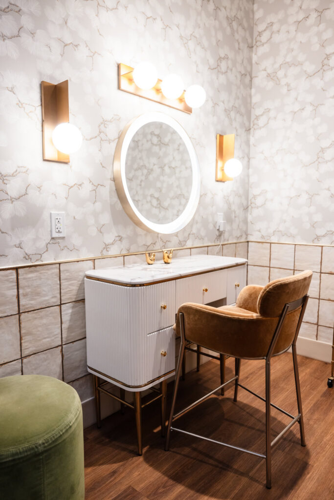 Vanity area inside the private wedding suite at Brooklyn Winery with illuminated mirror and upholstered chair.
