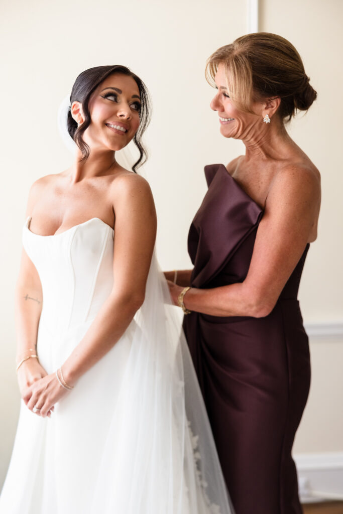 Christine shares a joyful moment with her mother while getting ready for her wedding at The Muttontown Club.