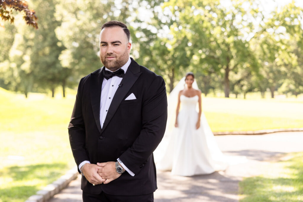 Matt waits for Christine during their first look near the golf course at The Muttontown Club.