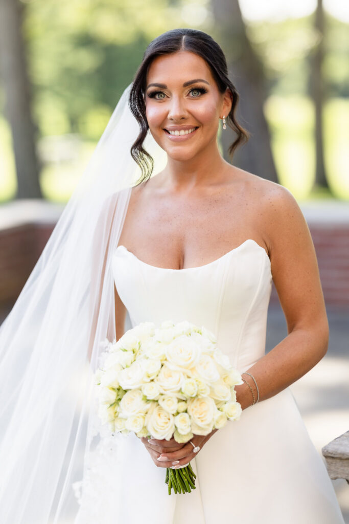 Bride holding a white rose bouquet during her wedding at The Muttontown Club.
