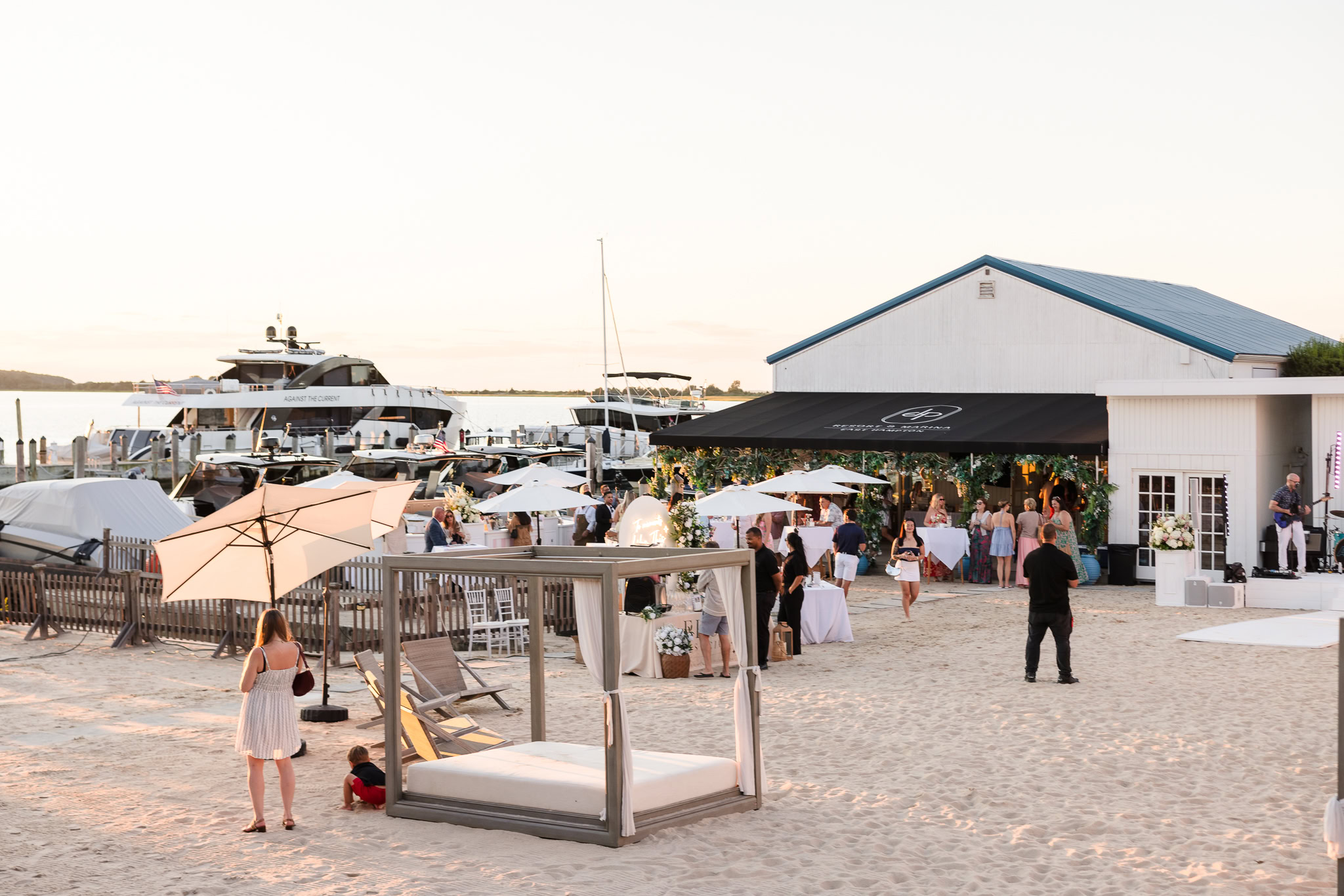 Wide view of the Great Lawn, marina, boats, and Shagwong Boat Club during an event at EHP Resort.