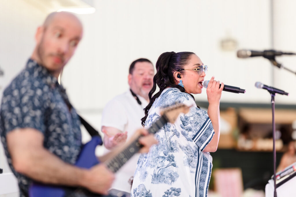 Vocalist performing with a live band during an outdoor waterfront event at EHP Resort in East Hampton.