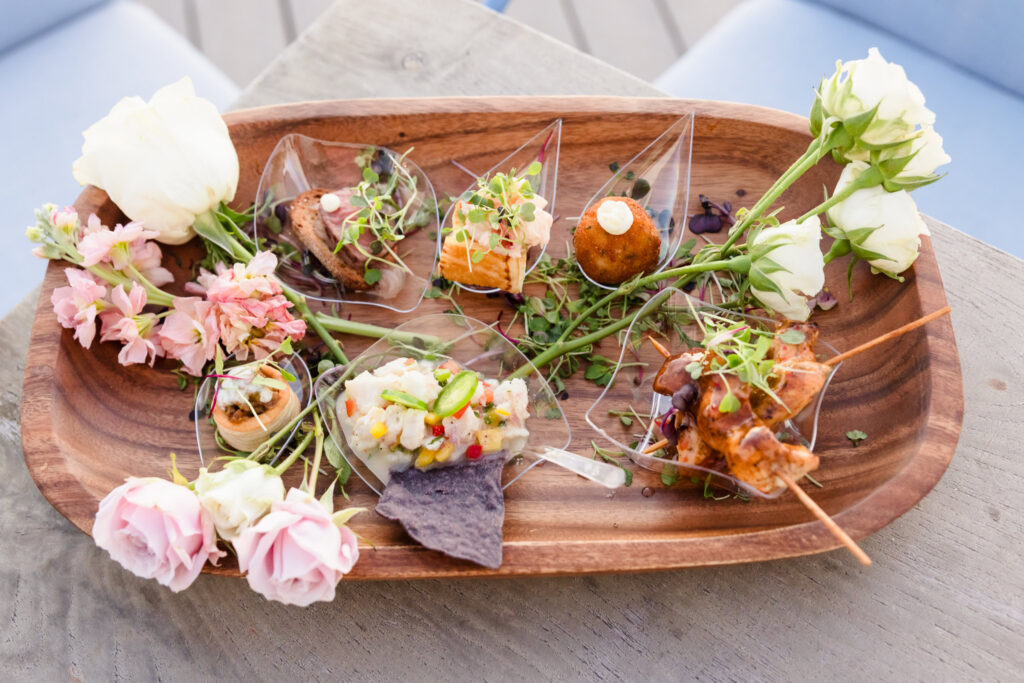 Passed appetizers displayed with fresh flowers during a waterfront event at EHP Resort in East Hampton.
