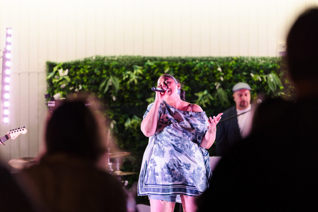 Female vocalist performing with a live band at Shagwong Boat Club.