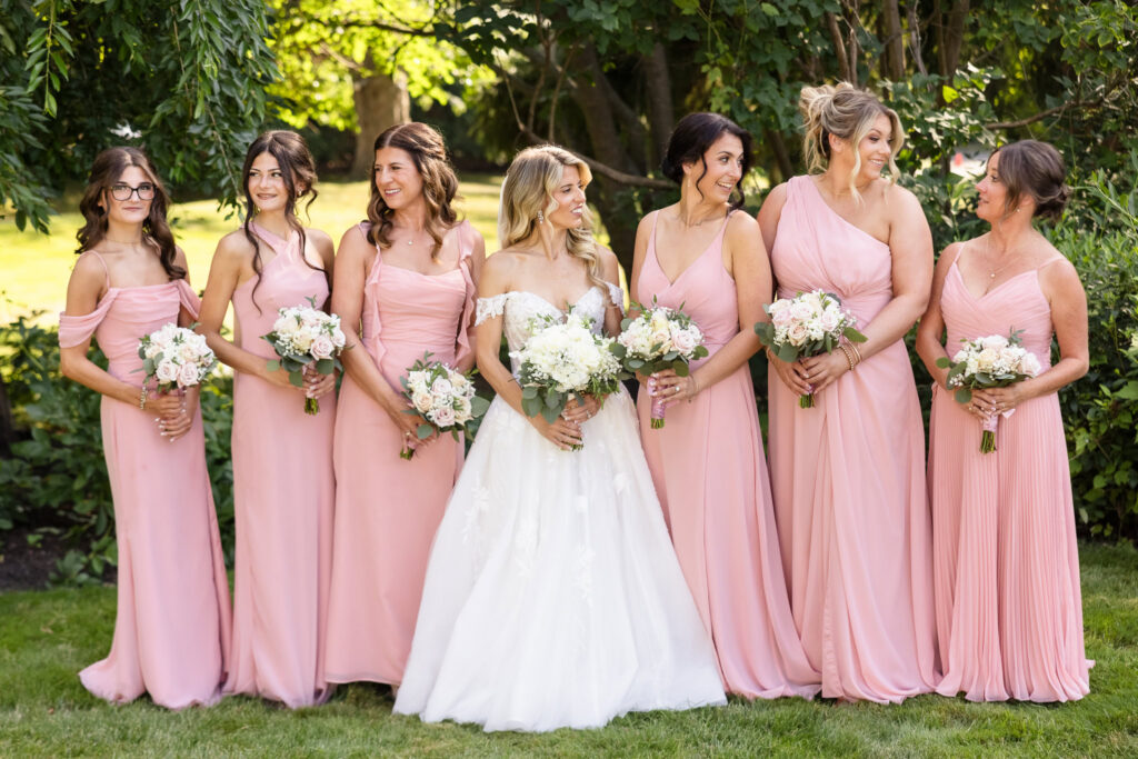 Kaity with her bridesmaids in soft pink dresses and white floral bouquets at Flowerfield.