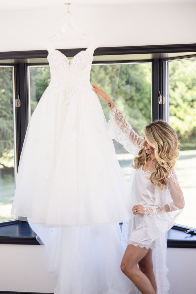 Kaity admiring her wedding dress while getting ready at the Rose Cottage at Flowerfield.
