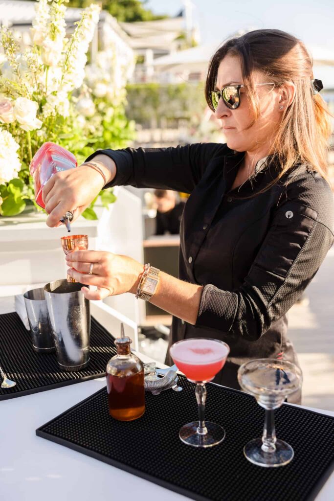 Bartender preparing a pink cocktail at the waterfront hamptonBRIDE event in East Hampton.