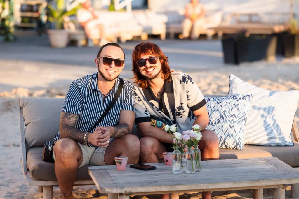 Two guests relaxing on a waterfront lounge during the summer cocktail party at EHP Resort.