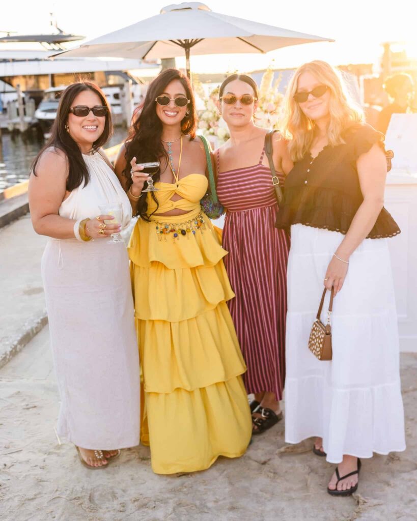 Four guests gathered beside the marina during sunset at hamptonBRIDE’s A Toast to Summer.