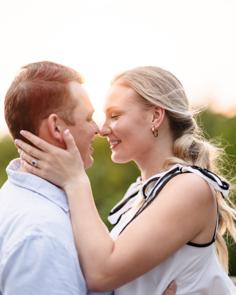 Emily holds Corbin close as they smile together in warm sunset light during their Robert Moses engagement session.