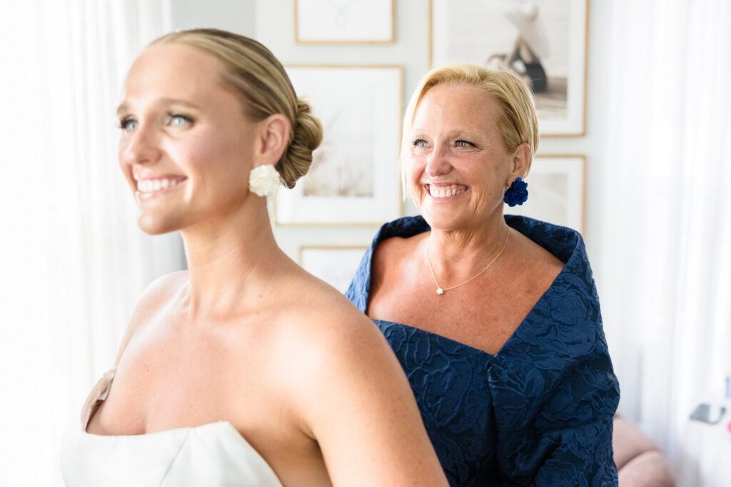 Bride and her mother smiling together during an emotional getting-ready moment before the wedding.
