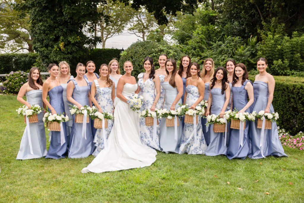 Quinn poses with her bridesmaids in blue and floral dresses during her large bridal party wedding at Sea Cliff Manor.