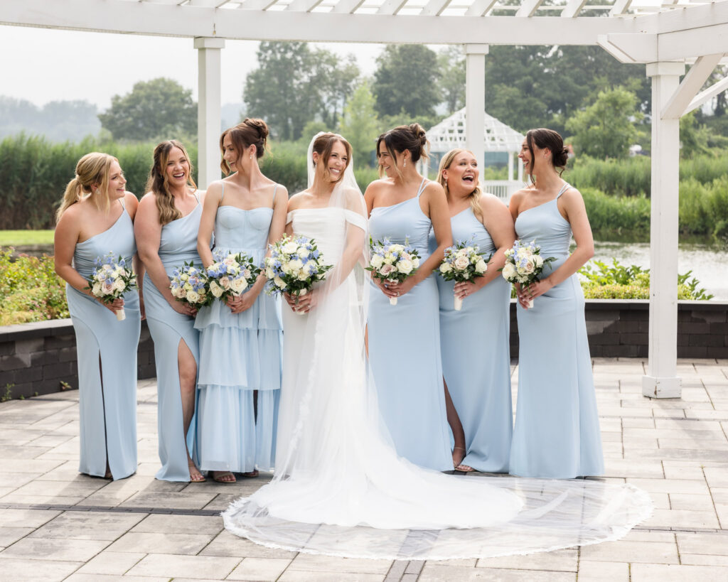 Tori laughing with her bridesmaids in light blue dresses during wedding party portraits at The Swan Club.