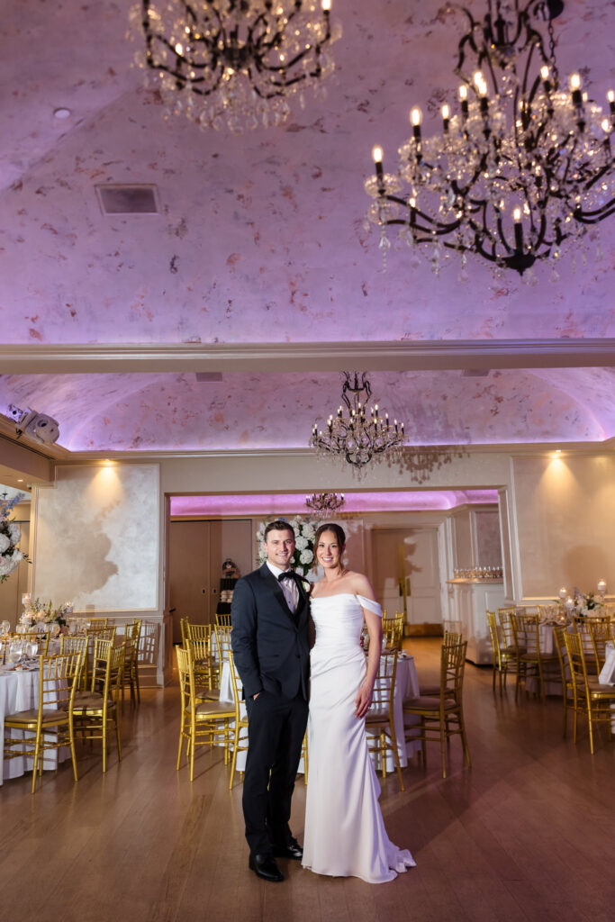 Crystal chandeliers and soft purple lighting above the decorated reception space at The Swan Club.
