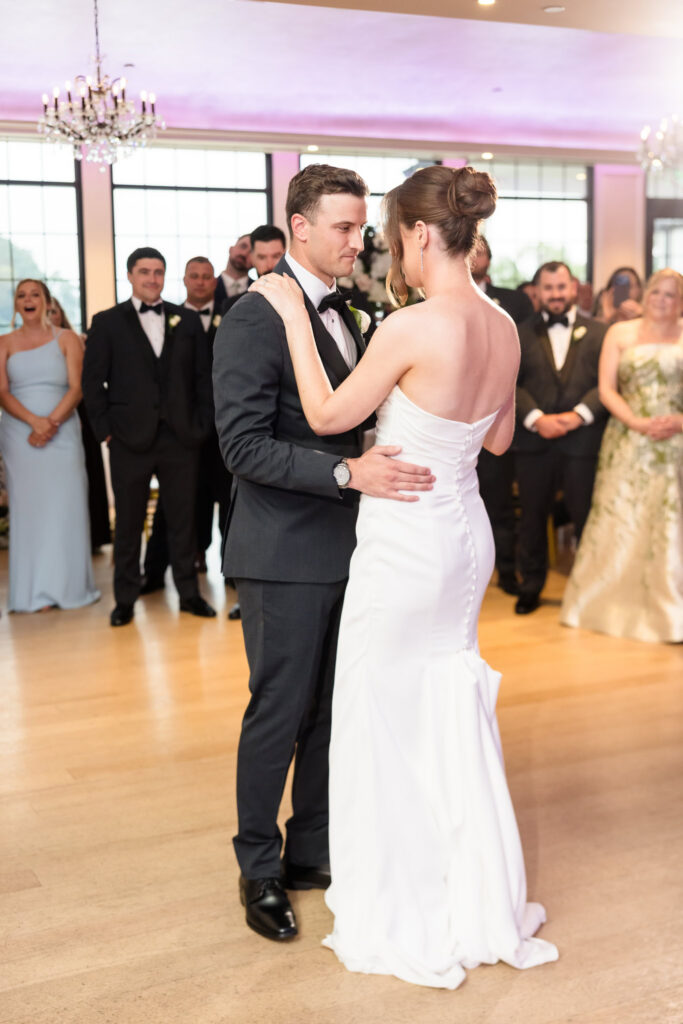 Tori and Mark smile at each other during their first dance at their Swan Club wedding reception.